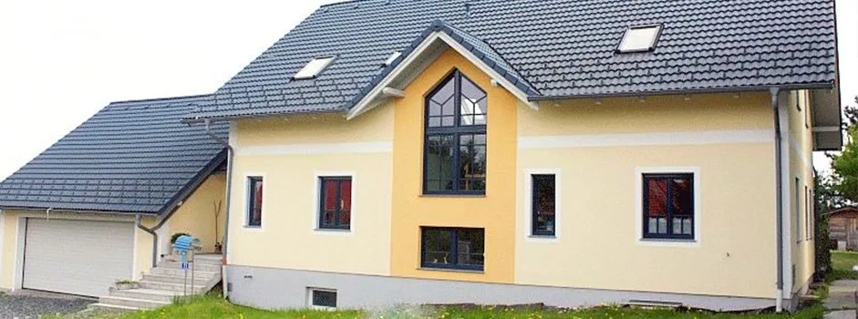 Gelbe Hausfassade mit weißer Gliederung