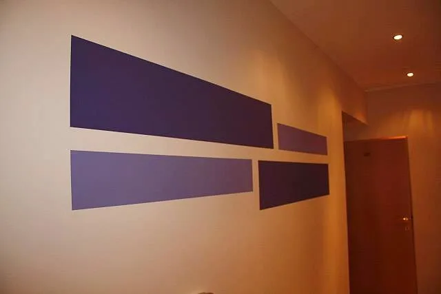 Violette geometrische Wandgestaltung in einem Gang